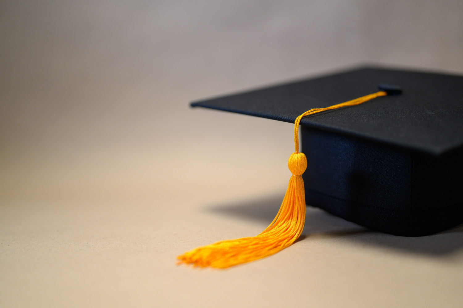 black-graduation-hat-placed-brown-paper